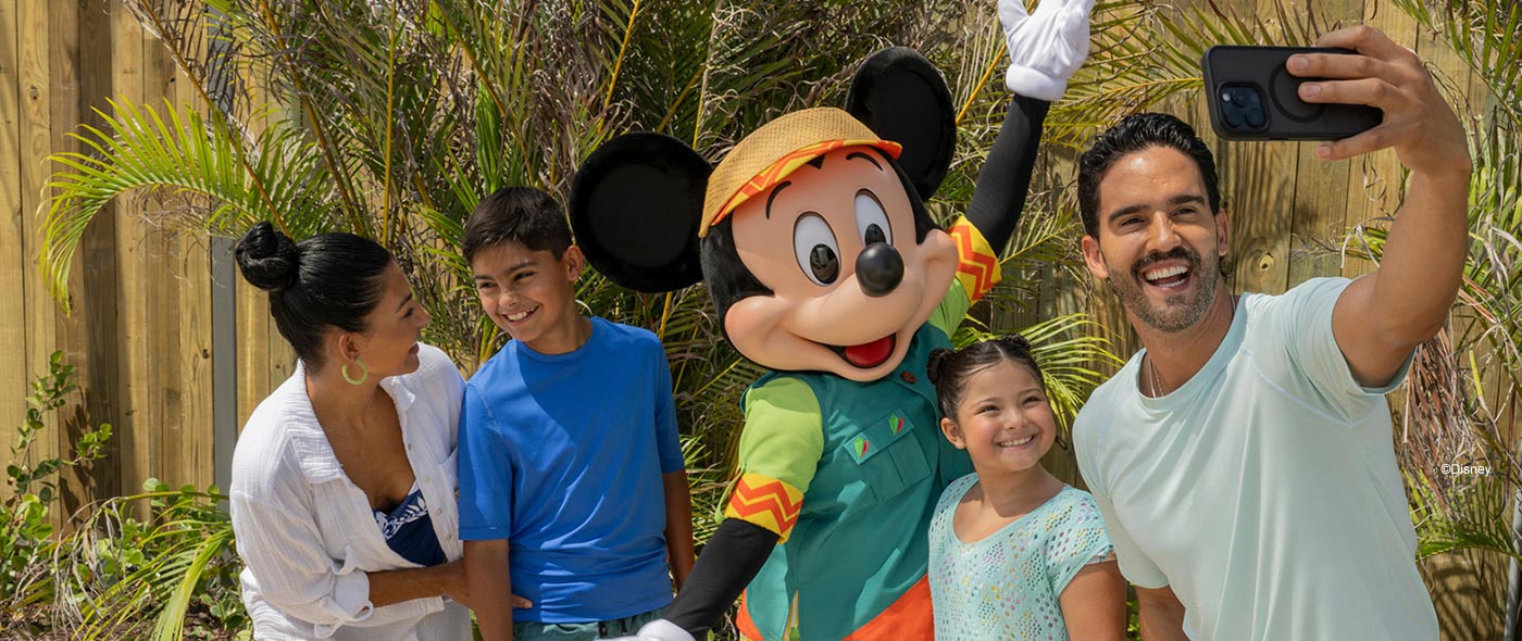 Image of a family taking a selfie with Mickey Mouse on a tropical island.