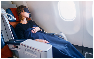 Woman sleeping with eye mask in an airplane