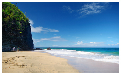 View of the Hanakapiai Beach with travelers walking by the cliffs