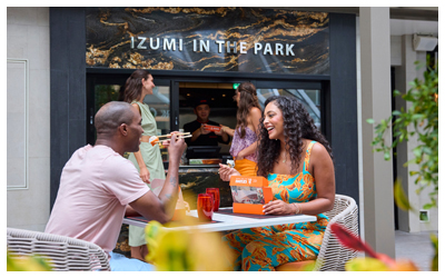 People eating sushi at a table in a courtyard