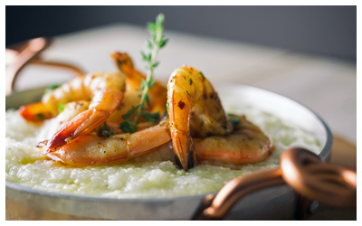 Cooked shrimp atop grits with herbs.